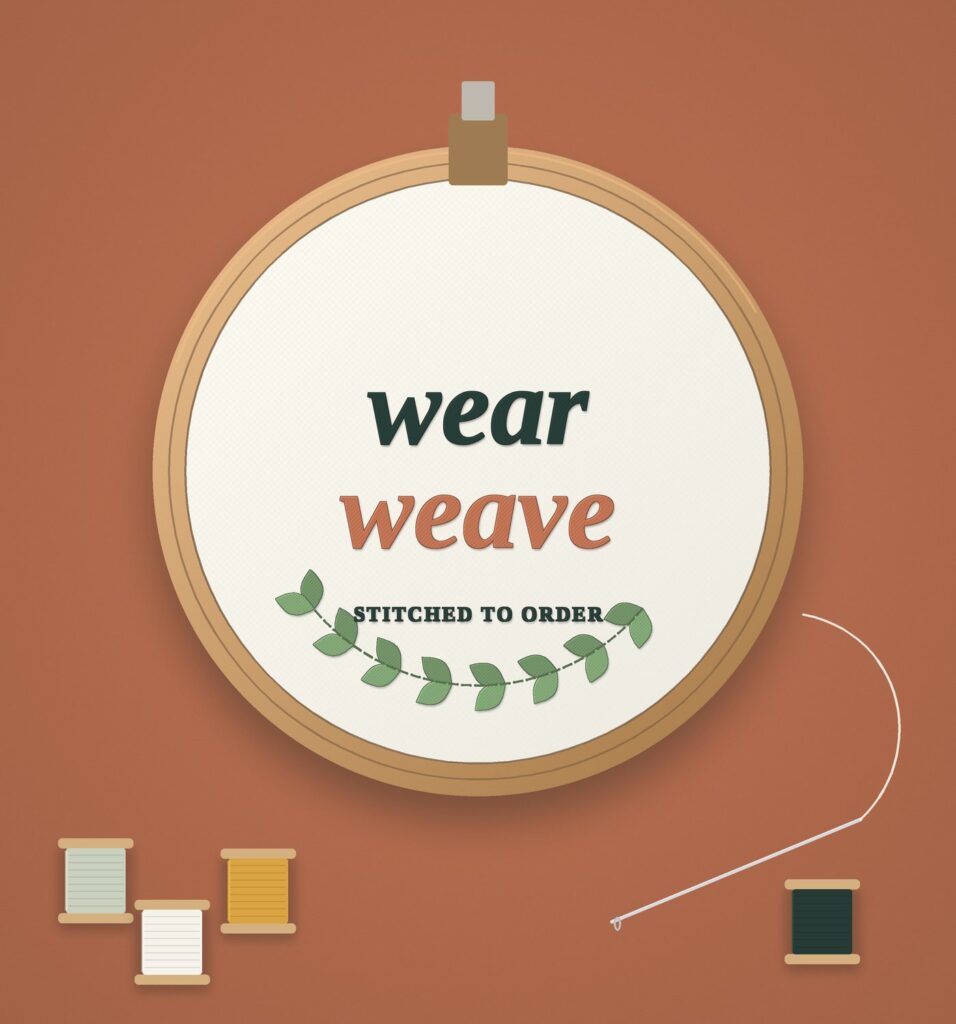 Embroidery hoop with the WearWeave name stitched in thread, surrounded by spools and a needle